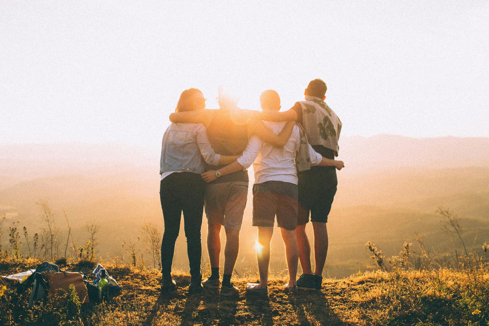 A group of friends embrace while enjoying a breathtaking sunrise over the Brazilian highlands.